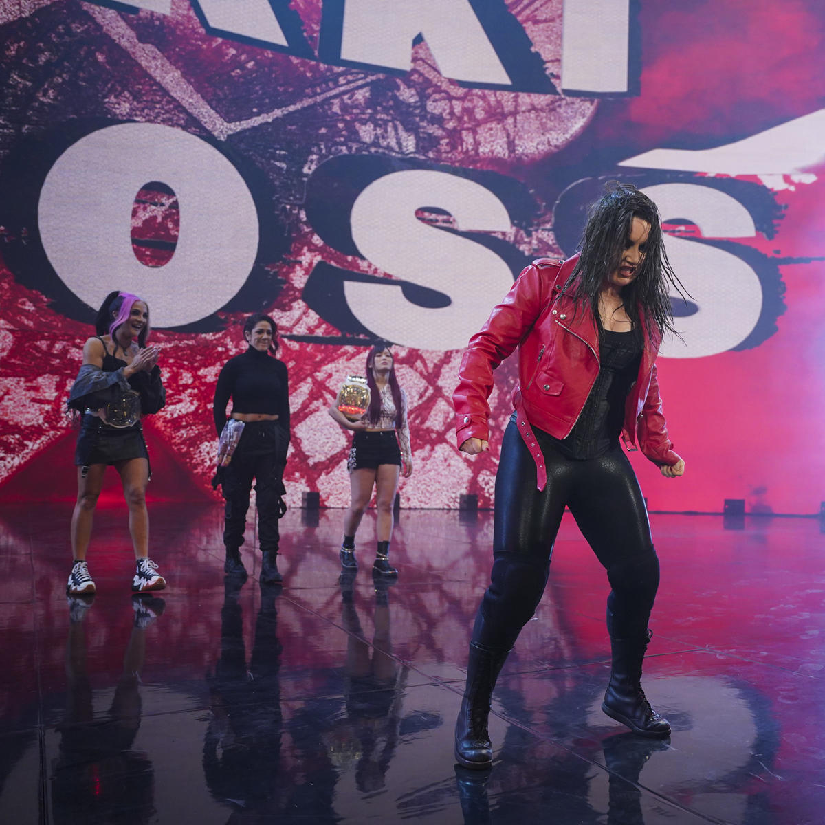 Nikki Cross makes her entrance during WWE Monday Night Raw, with Damage Control of Bayley, Dakota Kai and Iyo Sky watching on behind Cross.